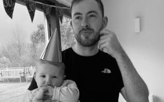 a person wearing a party hat holding a baby
