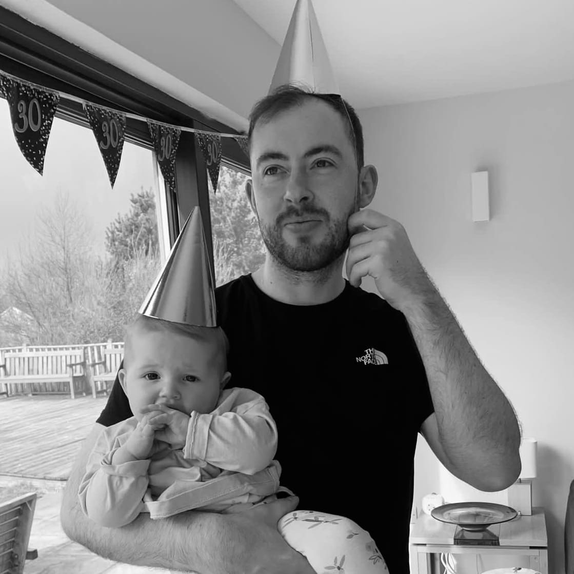 a person wearing a party hat holding a baby